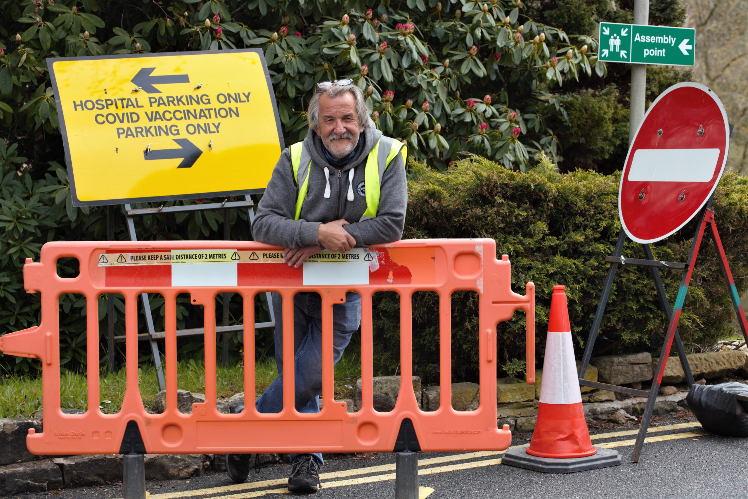 Man with glasses next to a road sign