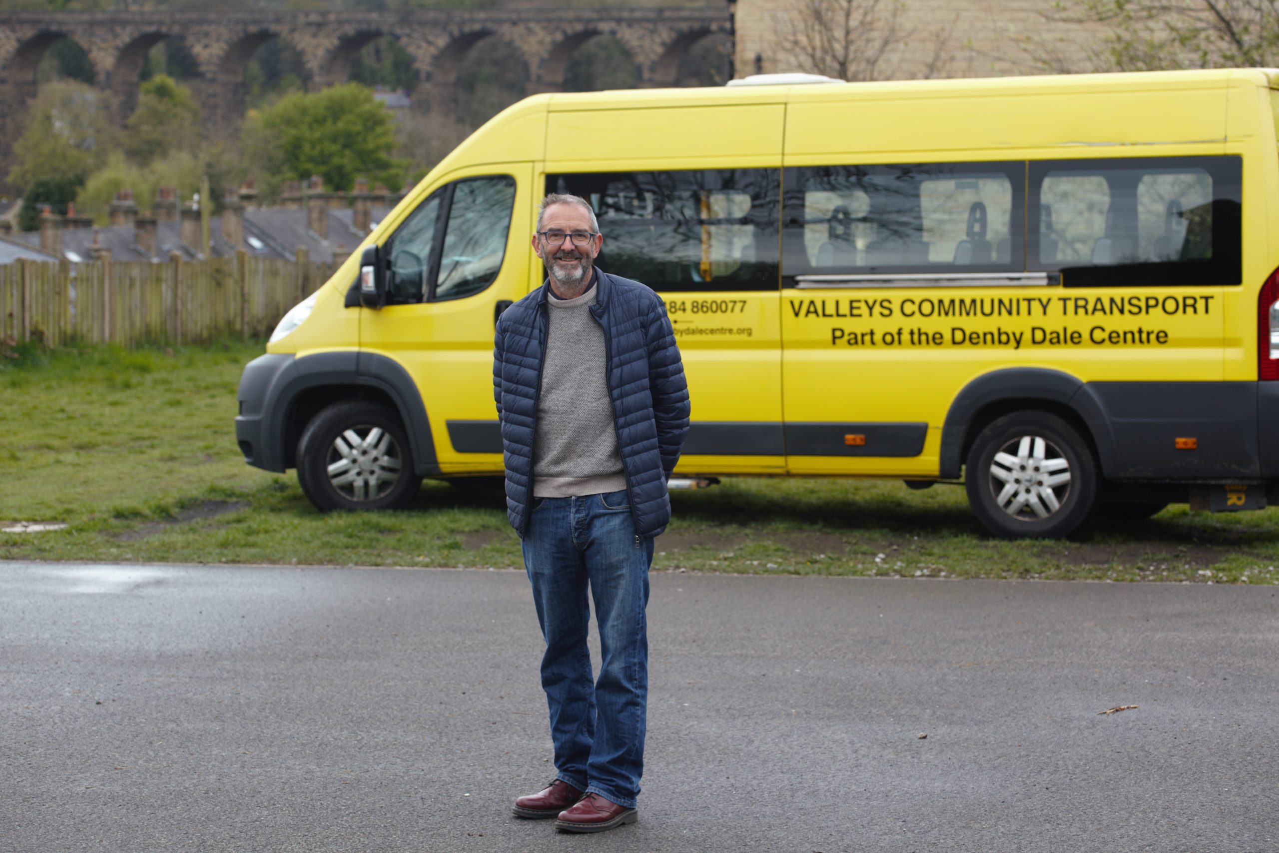 Man next to a transport van smiling