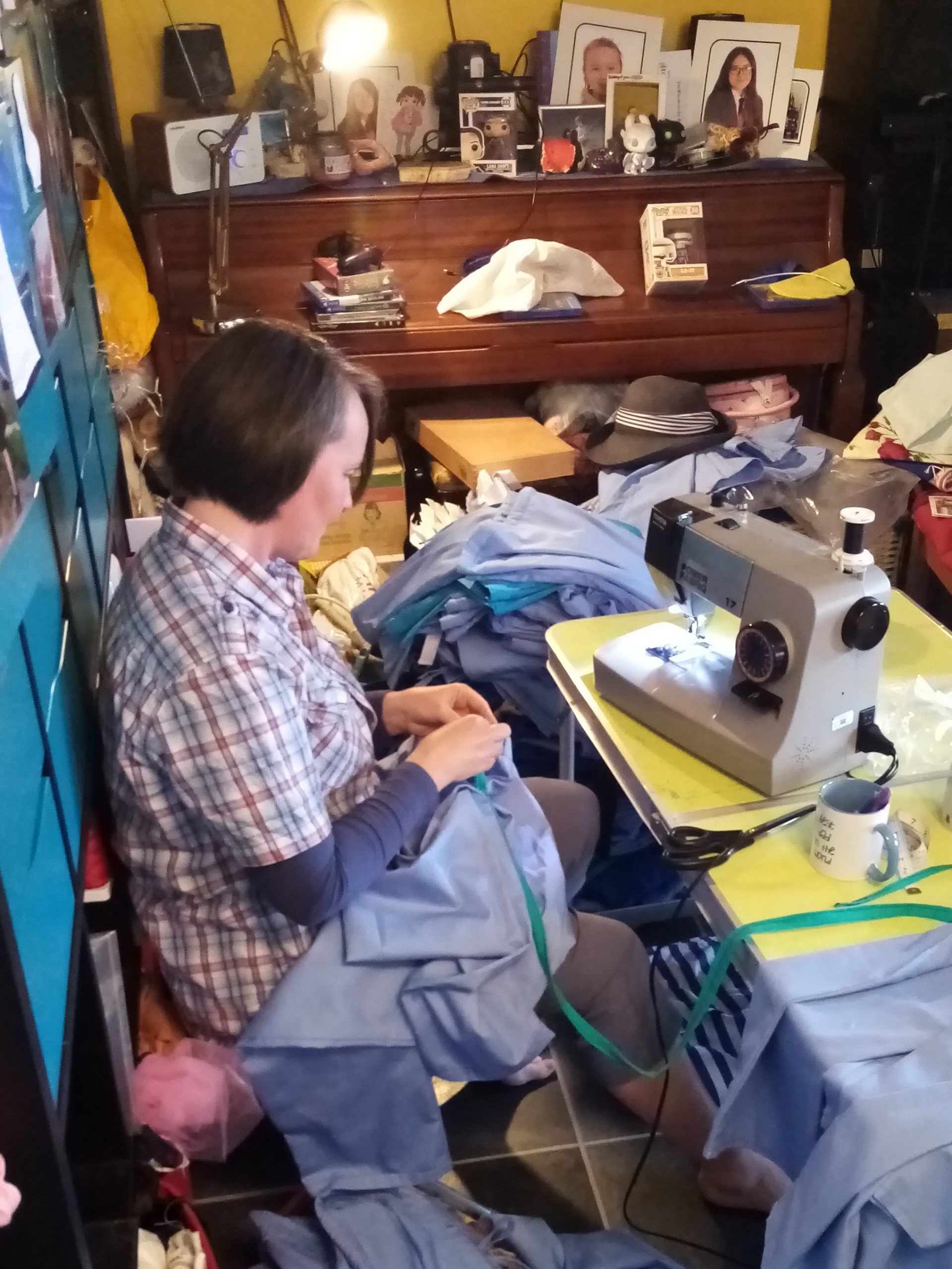 Amy busy sewing in her kitchen surrounded by fabric.