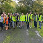 Team of volunteers wearing high vis in woodland area