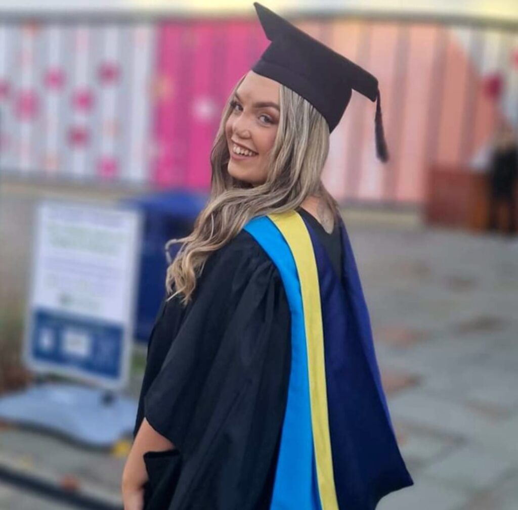 Joanne in her graduation gown, smiling